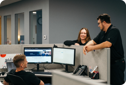 Three Clarity Technology Group team members in a natural office conversation
